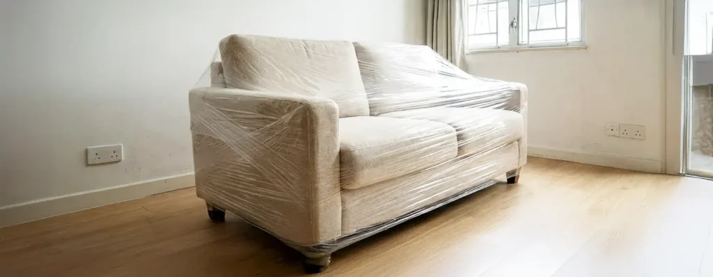 Sofa wrapped in protective stretch film for moving