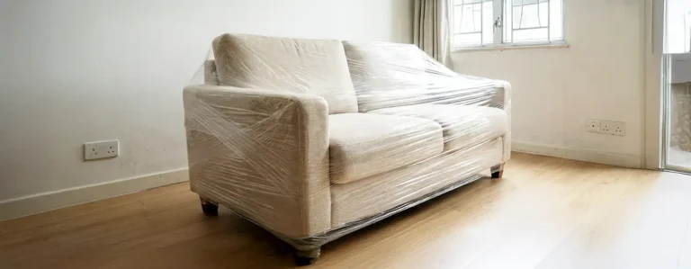 Sofa wrapped in protective stretch film for moving