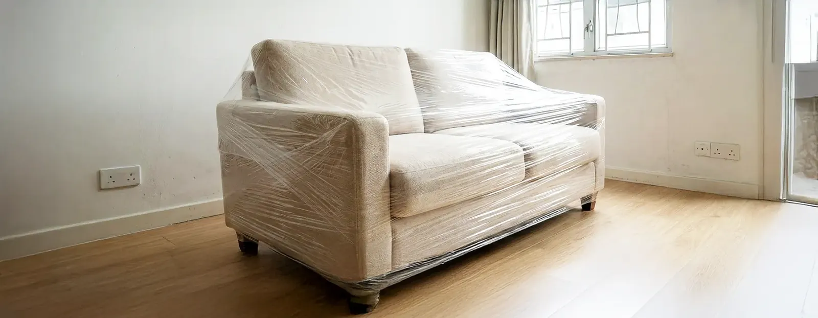 Sofa wrapped in protective stretch film for moving